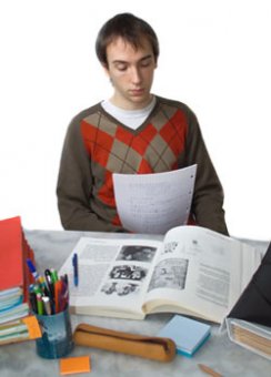 students is sitting at a desk reviewing records. A textbook is available available before him and he is deciding how he will compose a plan.